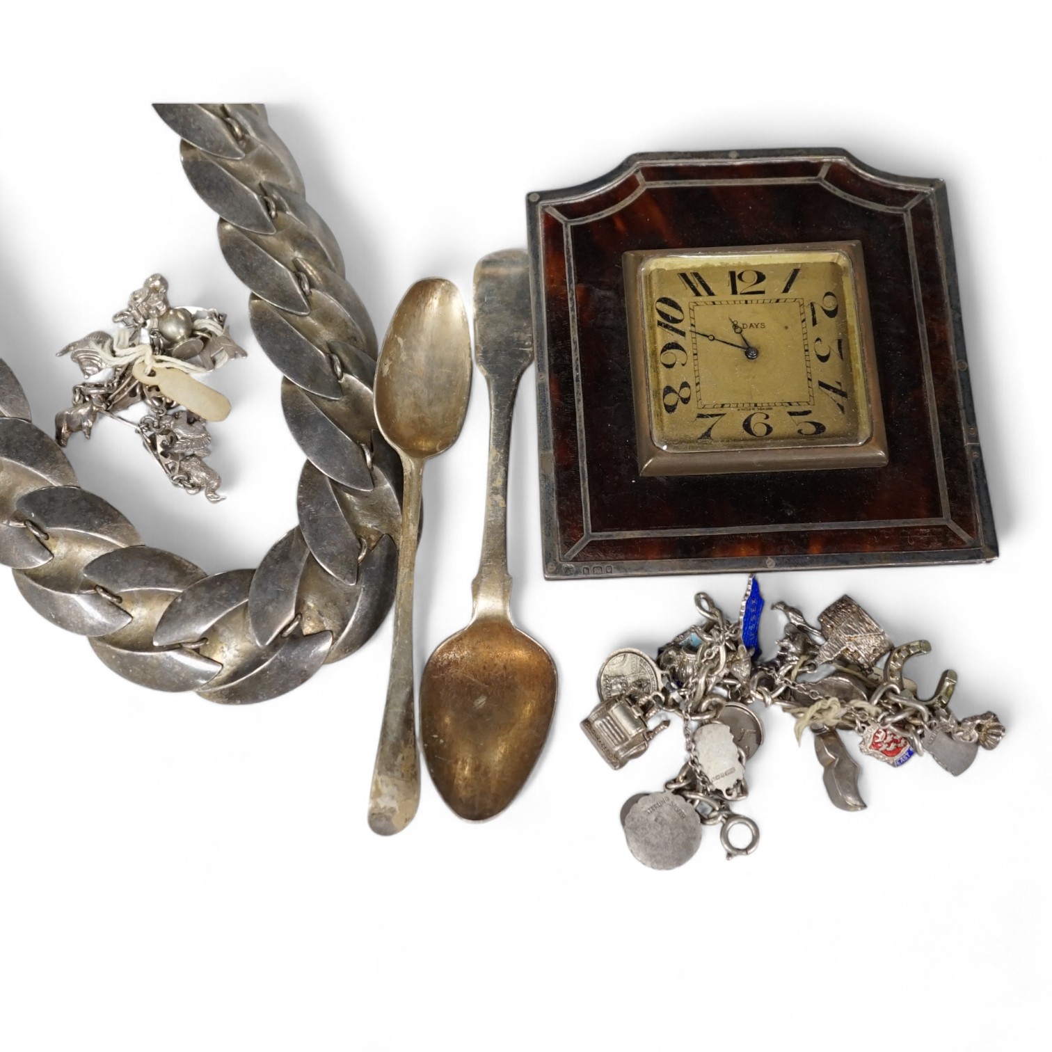 A silver charm bracelet, hung with assorted charms, some hallmarked, one other white metal charm bracelet, a stylish white metal necklace, two silver teaspoons and a George V silver and tortoiseshell mounted timepiece, L